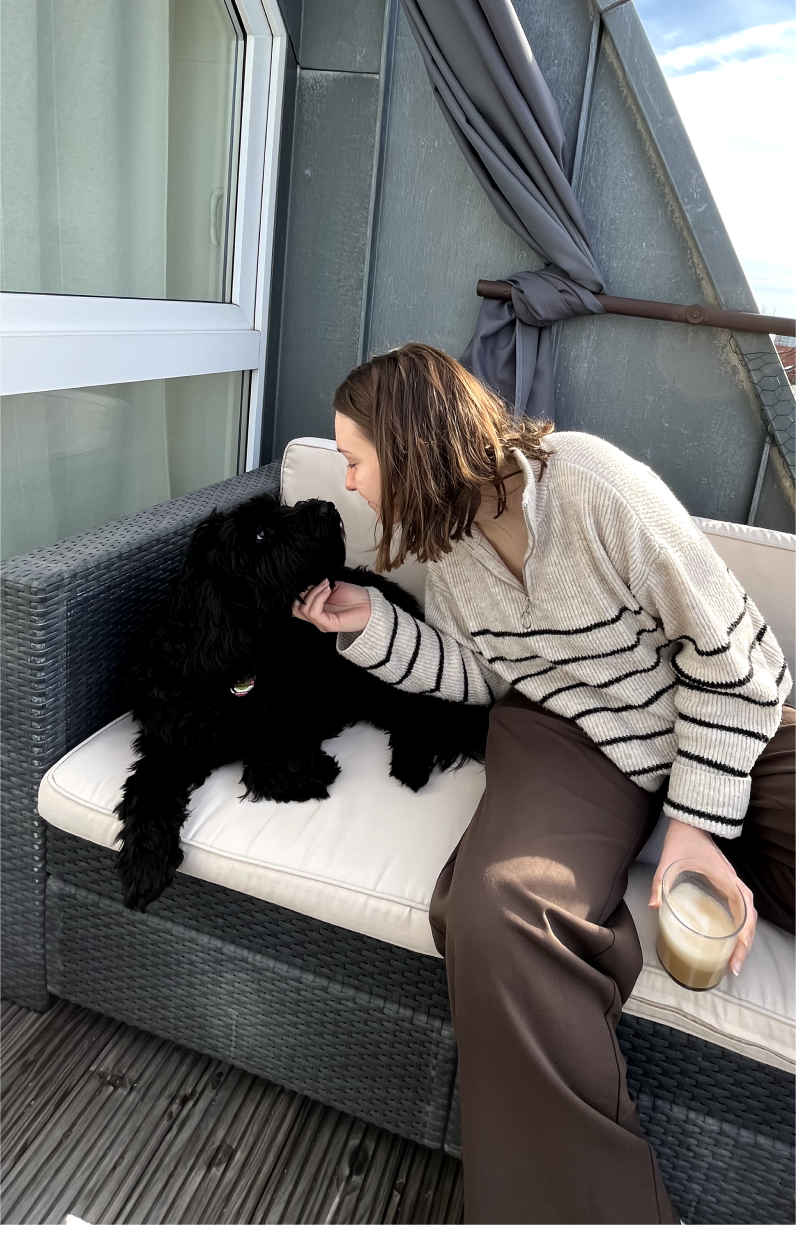 a woman and a dog sitting on a balcony